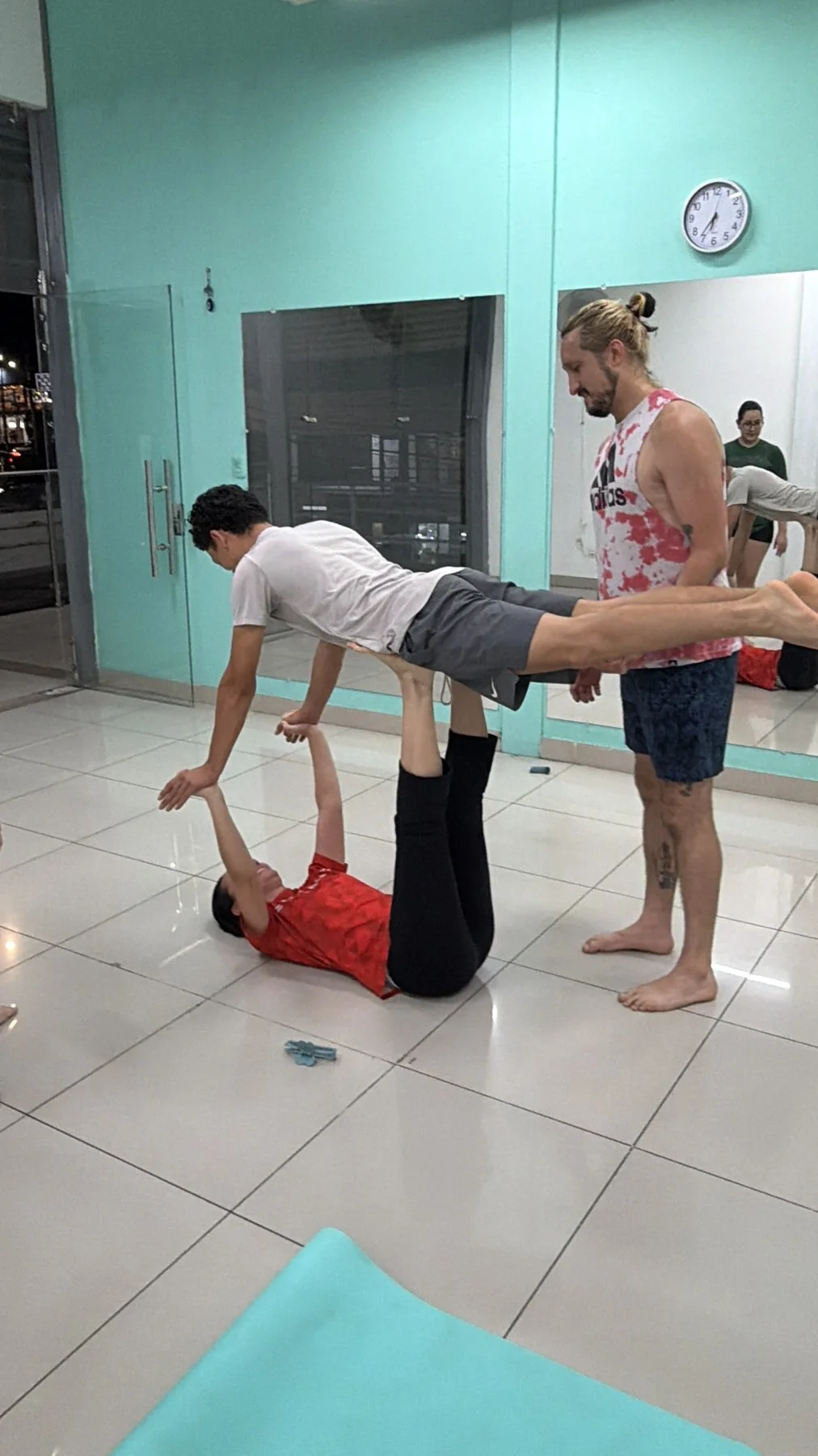Estudiantes realizando una figura de acroyoga con acompañamiento en Mon Talent
